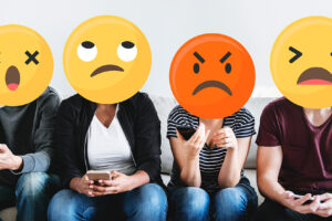 Foto de personas usando emojis amarillos en sus caras para representar las emociones y sentimientos de sorpresa enojo ira y tristeza