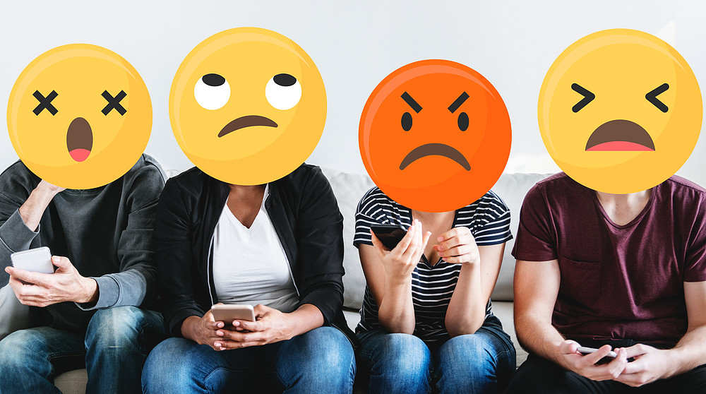 Foto de personas usando emojis amarillos en sus caras para representar las emociones y sentimientos de sorpresa enojo ira y tristeza